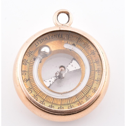 25 - A gold dual compass and barometer pendant. The gold pendant having a compass on one side with a baro... 