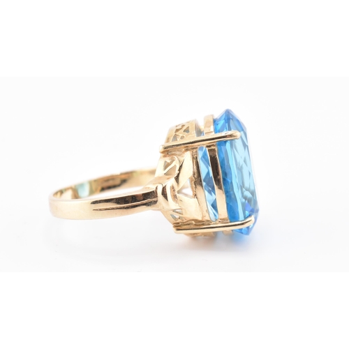 252 - A hallmarked 9ct gold and Swiss blue topaz ring. The 9ct yellow gold ring set with a single four cla... 