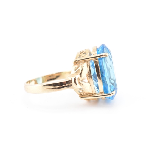 252 - A hallmarked 9ct gold and Swiss blue topaz ring. The 9ct yellow gold ring set with a single four cla... 