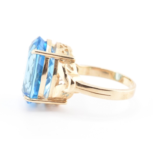 252 - A hallmarked 9ct gold and Swiss blue topaz ring. The 9ct yellow gold ring set with a single four cla... 