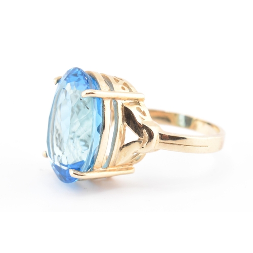 252 - A hallmarked 9ct gold and Swiss blue topaz ring. The 9ct yellow gold ring set with a single four cla... 