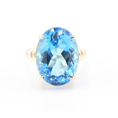 252 - A hallmarked 9ct gold and Swiss blue topaz ring. The 9ct yellow gold ring set with a single four cla... 