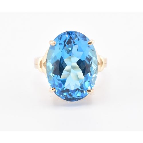 252 - A hallmarked 9ct gold and Swiss blue topaz ring. The 9ct yellow gold ring set with a single four cla... 