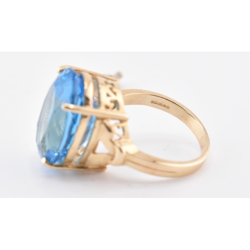 252 - A hallmarked 9ct gold and Swiss blue topaz ring. The 9ct yellow gold ring set with a single four cla... 