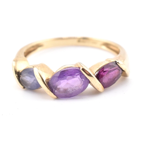 255 - A hallmarked 9ct gold amethyst, garnet and iolite three stone ring. The ring set with a single row c... 