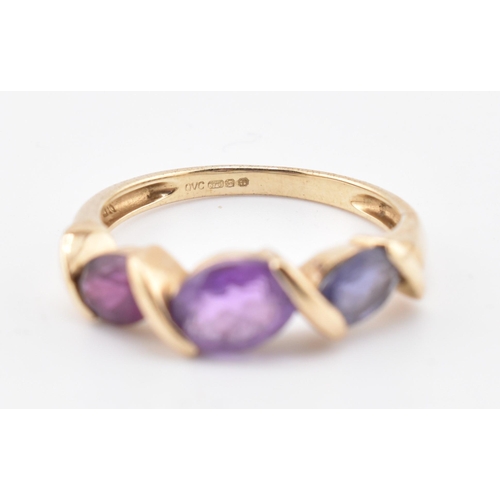 255 - A hallmarked 9ct gold amethyst, garnet and iolite three stone ring. The ring set with a single row c... 