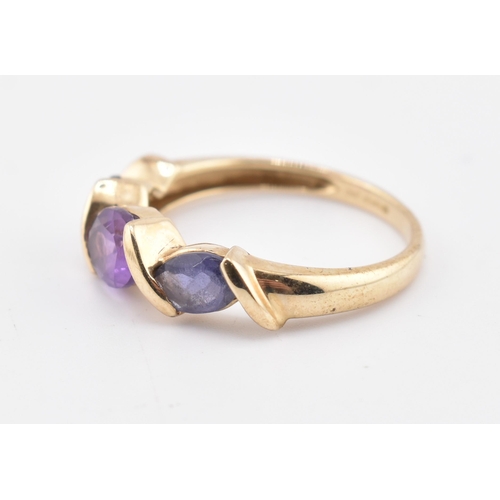 255 - A hallmarked 9ct gold amethyst, garnet and iolite three stone ring. The ring set with a single row c... 