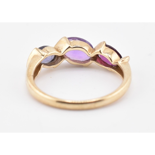 255 - A hallmarked 9ct gold amethyst, garnet and iolite three stone ring. The ring set with a single row c... 