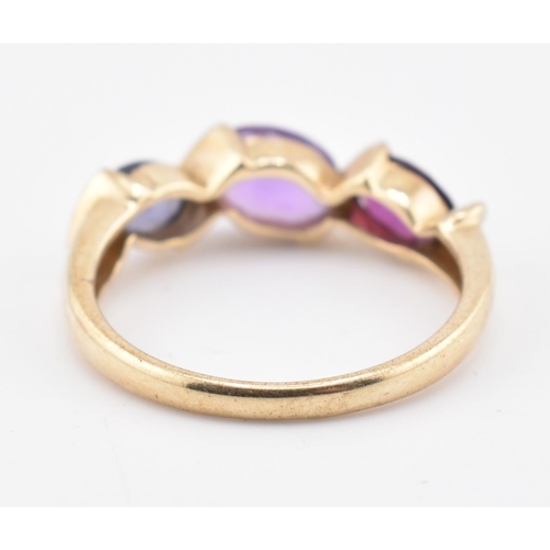 255 - A hallmarked 9ct gold amethyst, garnet and iolite three stone ring. The ring set with a single row c... 