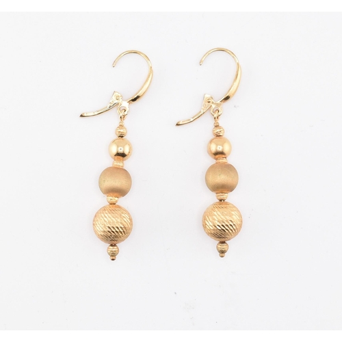 258 - A pair of 9ct gold graduated ball drop pendant earrings having lever clasps. Marked 375. Weighs 3.3g... 