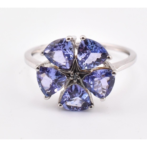 260 - A hallmarked 9ct white gold tanzanite and blue diamond flower ring. The 9ct white gold ring set with... 