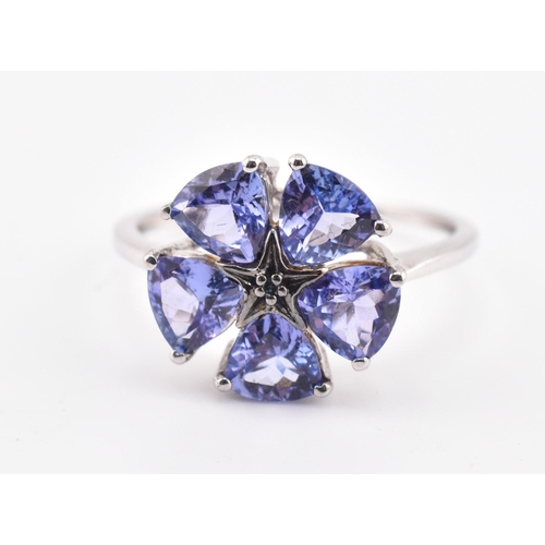 260 - A hallmarked 9ct white gold tanzanite and blue diamond flower ring. The 9ct white gold ring set with... 