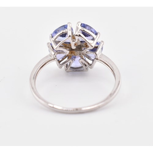 260 - A hallmarked 9ct white gold tanzanite and blue diamond flower ring. The 9ct white gold ring set with... 