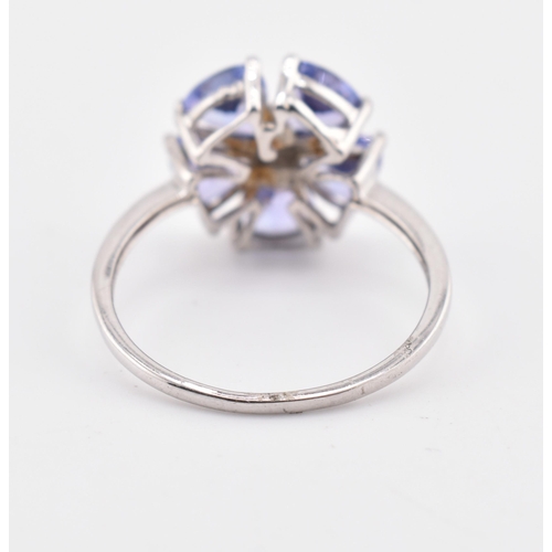 260 - A hallmarked 9ct white gold tanzanite and blue diamond flower ring. The 9ct white gold ring set with... 