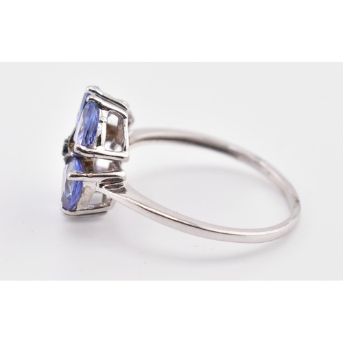 260 - A hallmarked 9ct white gold tanzanite and blue diamond flower ring. The 9ct white gold ring set with... 