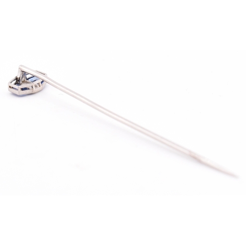 27 - A sapphire and diamond stick pin. The white gold stick pin having a head set with a central marquise... 