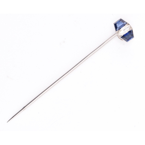 27 - A sapphire and diamond stick pin. The white gold stick pin having a head set with a central marquise... 