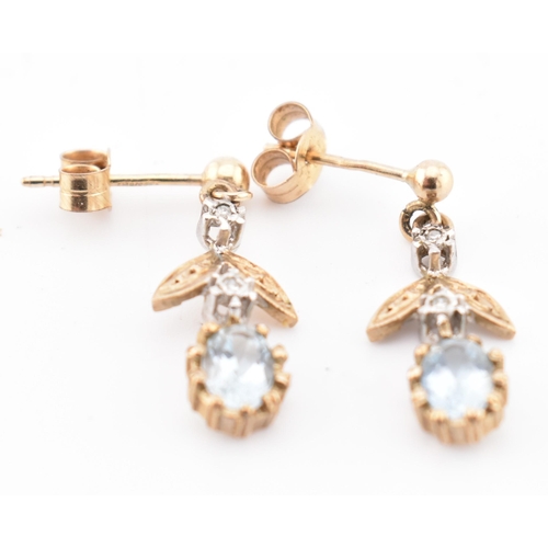 28 - A pair of hallmarked 9ct gold, aquamarine and diamond pendant earrings. The 9ct yellow gold earrings... 