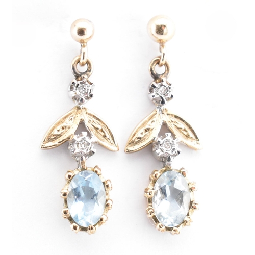 28 - A pair of hallmarked 9ct gold, aquamarine and diamond pendant earrings. The 9ct yellow gold earrings... 