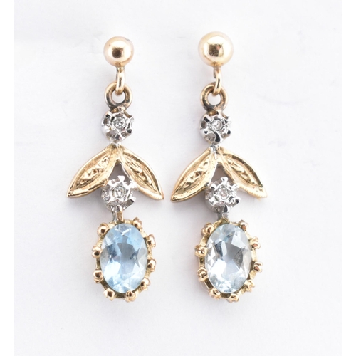 28 - A pair of hallmarked 9ct gold, aquamarine and diamond pendant earrings. The 9ct yellow gold earrings... 