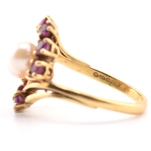 31 - A hallmarked 18ct gold ruby and pearl crossover ring. The 18ct yellow gold ring set with two round p... 