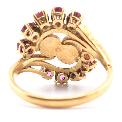 31 - A hallmarked 18ct gold ruby and pearl crossover ring. The 18ct yellow gold ring set with two round p... 