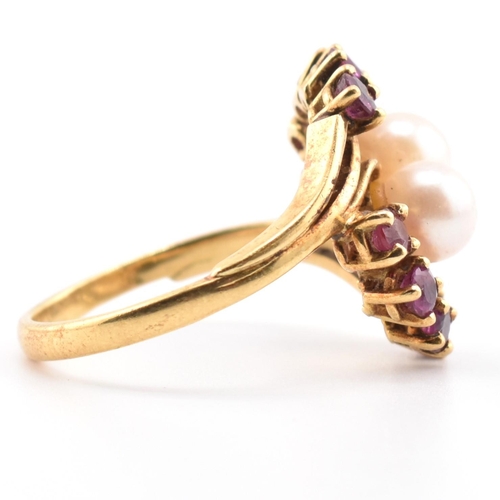 31 - A hallmarked 18ct gold ruby and pearl crossover ring. The 18ct yellow gold ring set with two round p... 