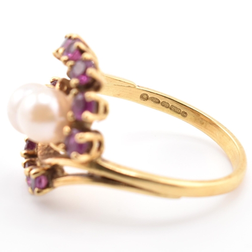 31 - A hallmarked 18ct gold ruby and pearl crossover ring. The 18ct yellow gold ring set with two round p... 