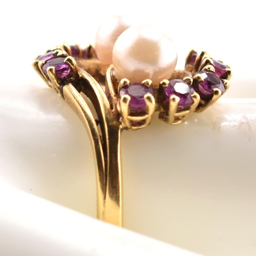 31 - A hallmarked 18ct gold ruby and pearl crossover ring. The 18ct yellow gold ring set with two round p... 