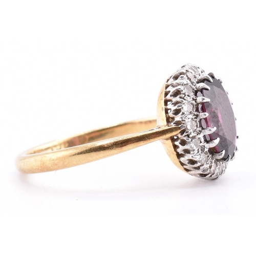 31A - An 18ct gold and platinum garnet and diamond cluster ring. The 18ct yellow gold ring set with a claw... 