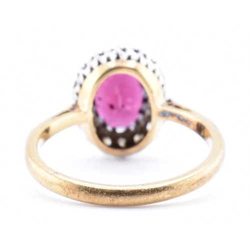 31A - An 18ct gold and platinum garnet and diamond cluster ring. The 18ct yellow gold ring set with a claw... 