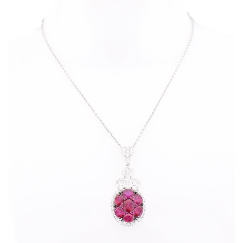 32 - An 18ct white gold, ruby and diamond pendant. The 18ct white gold necklace pendant having seven oval... 