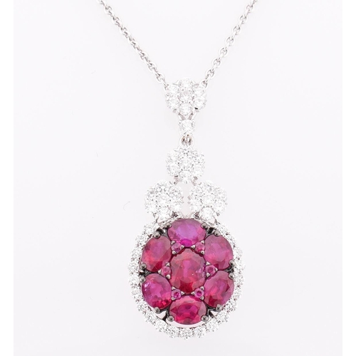 32 - An 18ct white gold, ruby and diamond pendant. The 18ct white gold necklace pendant having seven oval... 