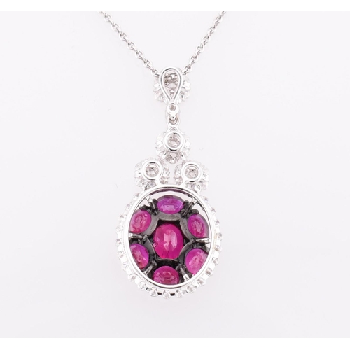 32 - An 18ct white gold, ruby and diamond pendant. The 18ct white gold necklace pendant having seven oval... 