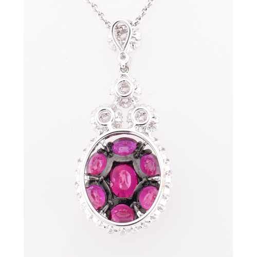 32 - An 18ct white gold, ruby and diamond pendant. The 18ct white gold necklace pendant having seven oval... 