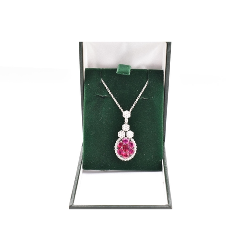 32 - An 18ct white gold, ruby and diamond pendant. The 18ct white gold necklace pendant having seven oval... 