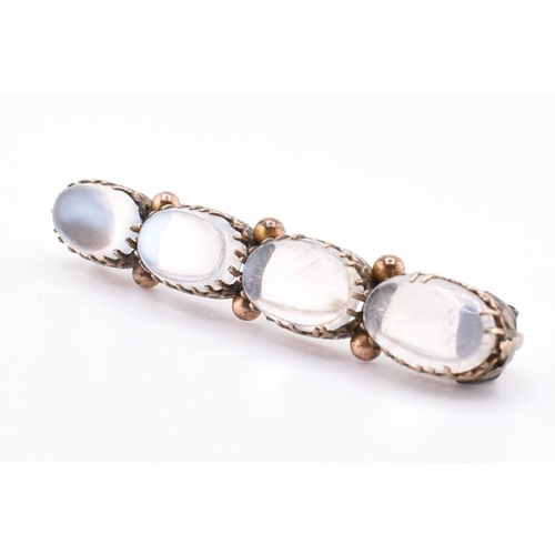 32A - A gold and moonstone brooch pin. The gold brooch pin set with four claw set oval moonstone cabochons... 