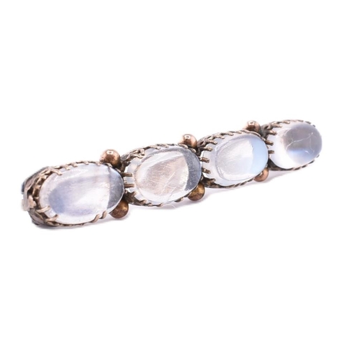 32A - A gold and moonstone brooch pin. The gold brooch pin set with four claw set oval moonstone cabochons... 