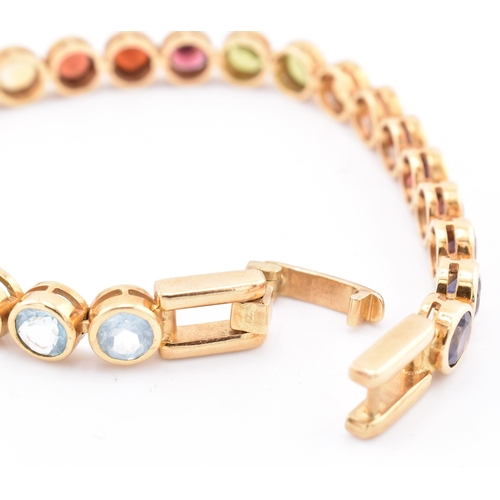 35 - An 18ct gold multi gem set tennis bracelet. The bracelet having twenty-five bezel set gems including... 