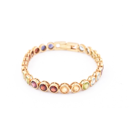 35 - An 18ct gold multi gem set tennis bracelet. The bracelet having twenty-five bezel set gems including... 