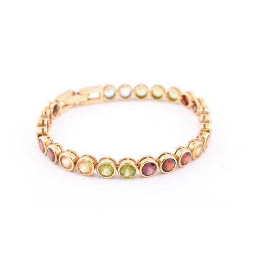 35 - An 18ct gold multi gem set tennis bracelet. The bracelet having twenty-five bezel set gems including... 