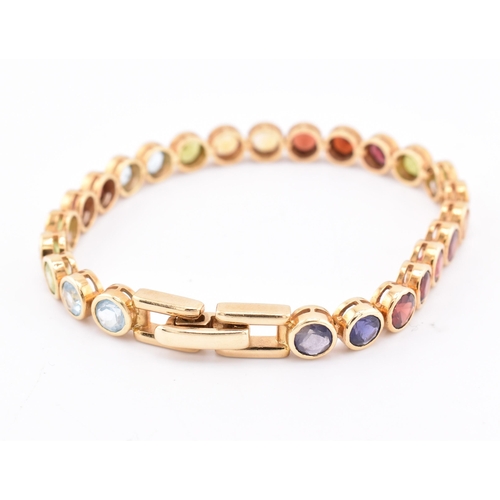 35 - An 18ct gold multi gem set tennis bracelet. The bracelet having twenty-five bezel set gems including... 