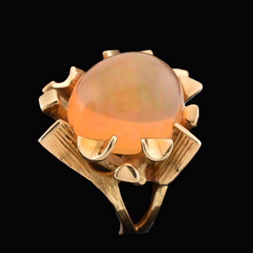 37 - An 18ct gold Mexican opal ring. The ring set with a high opal cabochon set amongst naturalistic fron... 