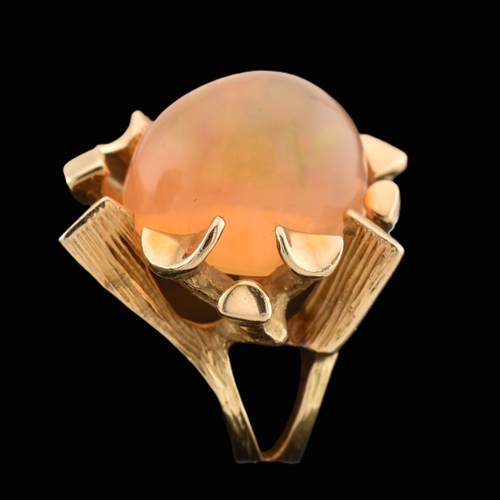 37 - An 18ct gold Mexican opal ring. The ring set with a high opal cabochon set amongst naturalistic fron... 