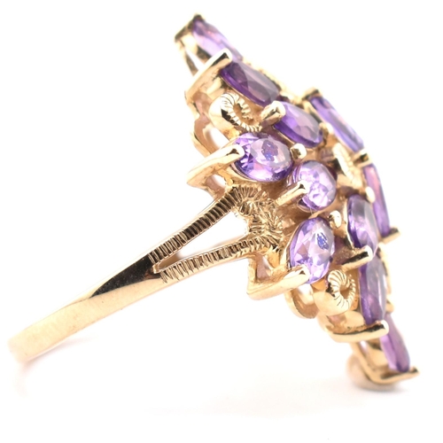 43 - A hallmarked 9ct gold and amethyst cluster ring. The 9ct yellow gold ring having a cluster of 18 ova... 