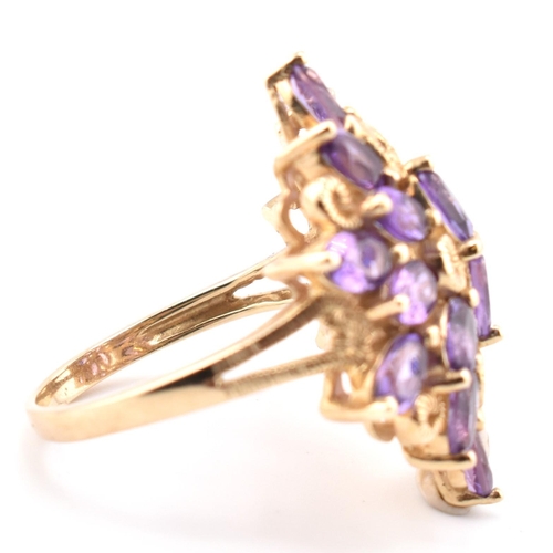 43 - A hallmarked 9ct gold and amethyst cluster ring. The 9ct yellow gold ring having a cluster of 18 ova... 