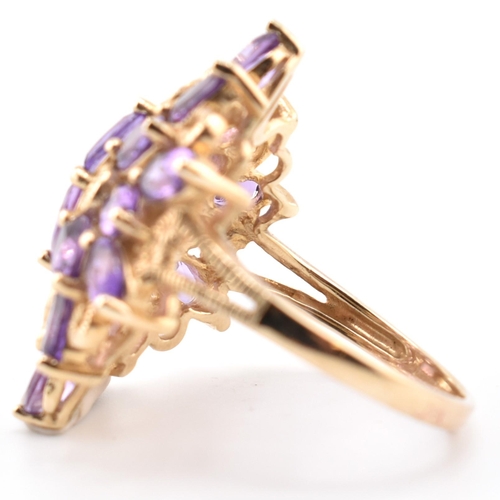 43 - A hallmarked 9ct gold and amethyst cluster ring. The 9ct yellow gold ring having a cluster of 18 ova... 