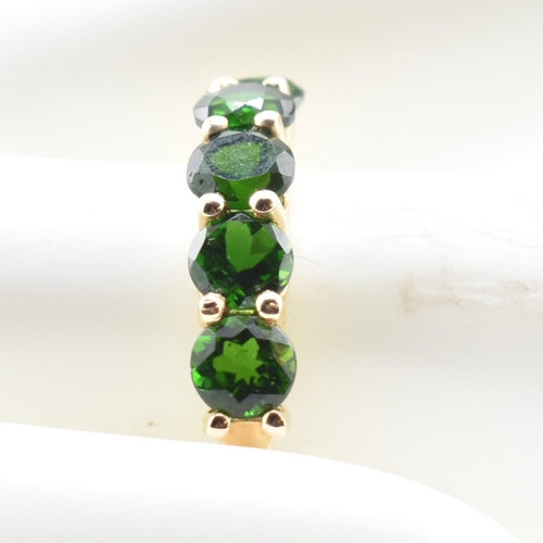 48 - A hallmarked 9ct gold and chrome diopside five stone ring. The ring having a single row of five shar... 