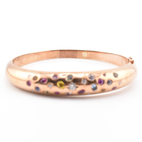 49a - A hallmarked 9ct rose gold sapphire, diamond gem set bombe bangle. The hinged bangle set with diamon... 