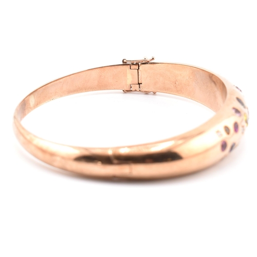 49a - A hallmarked 9ct rose gold sapphire, diamond gem set bombe bangle. The hinged bangle set with diamon... 